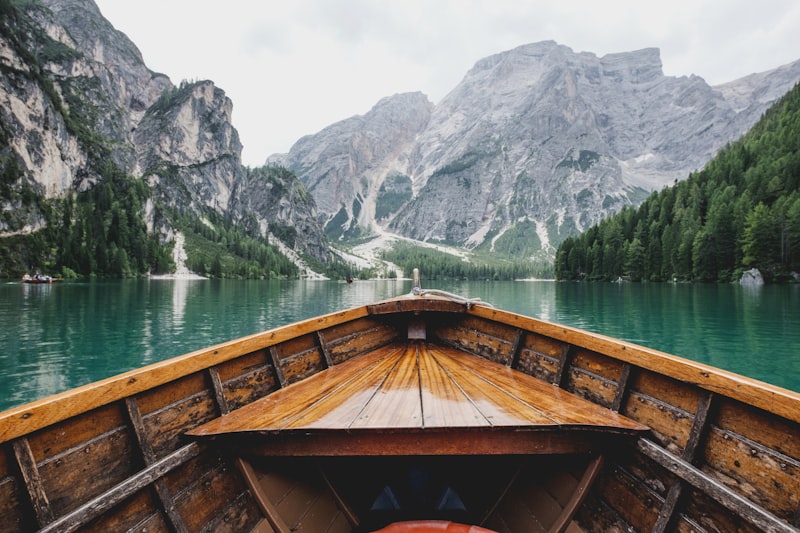 Beautiful wooden boat floating on quiet water representing customized travel plan